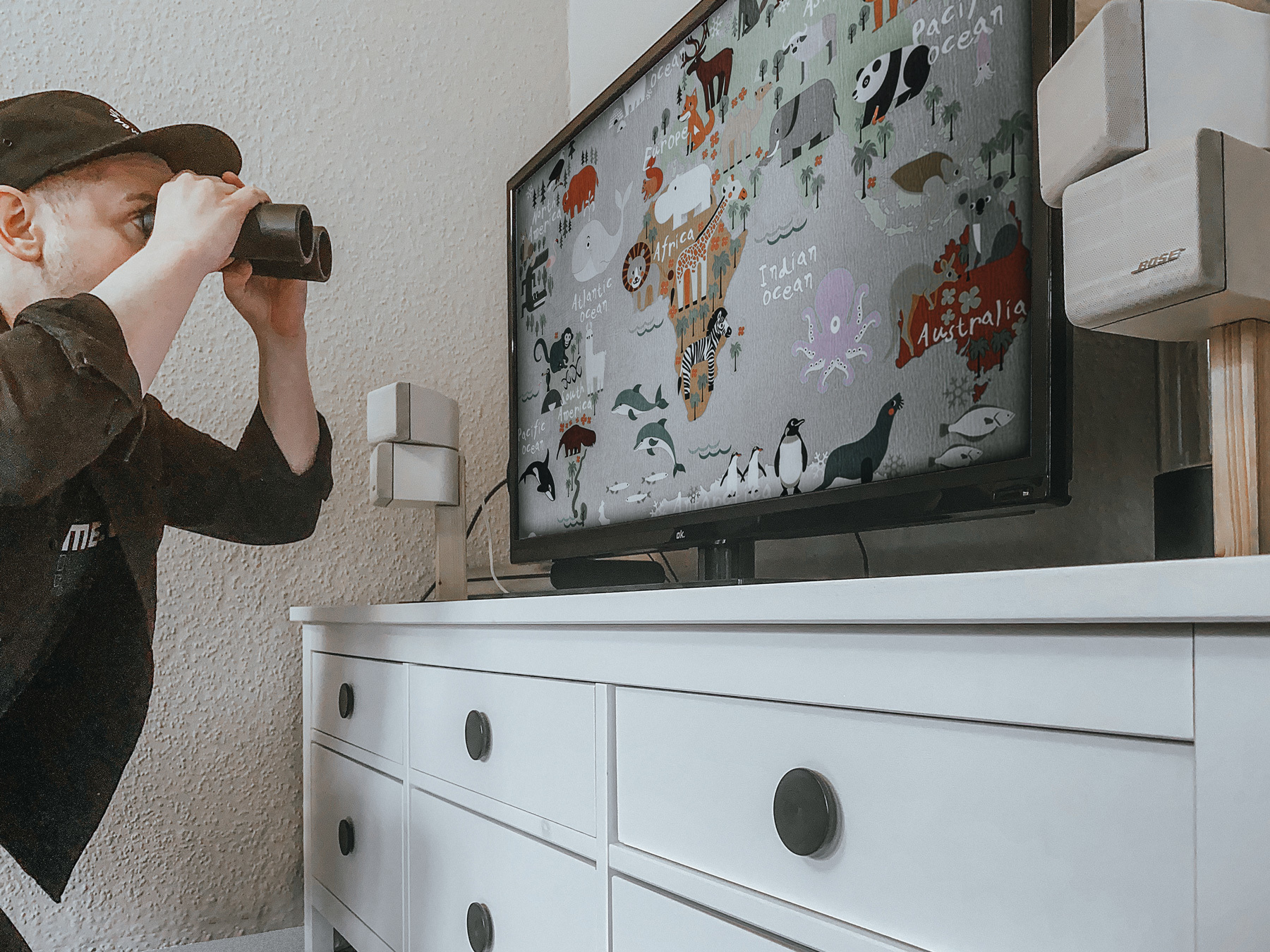 Die Weltkarte auf dem Fernseher mit dem Fernglas entdecken